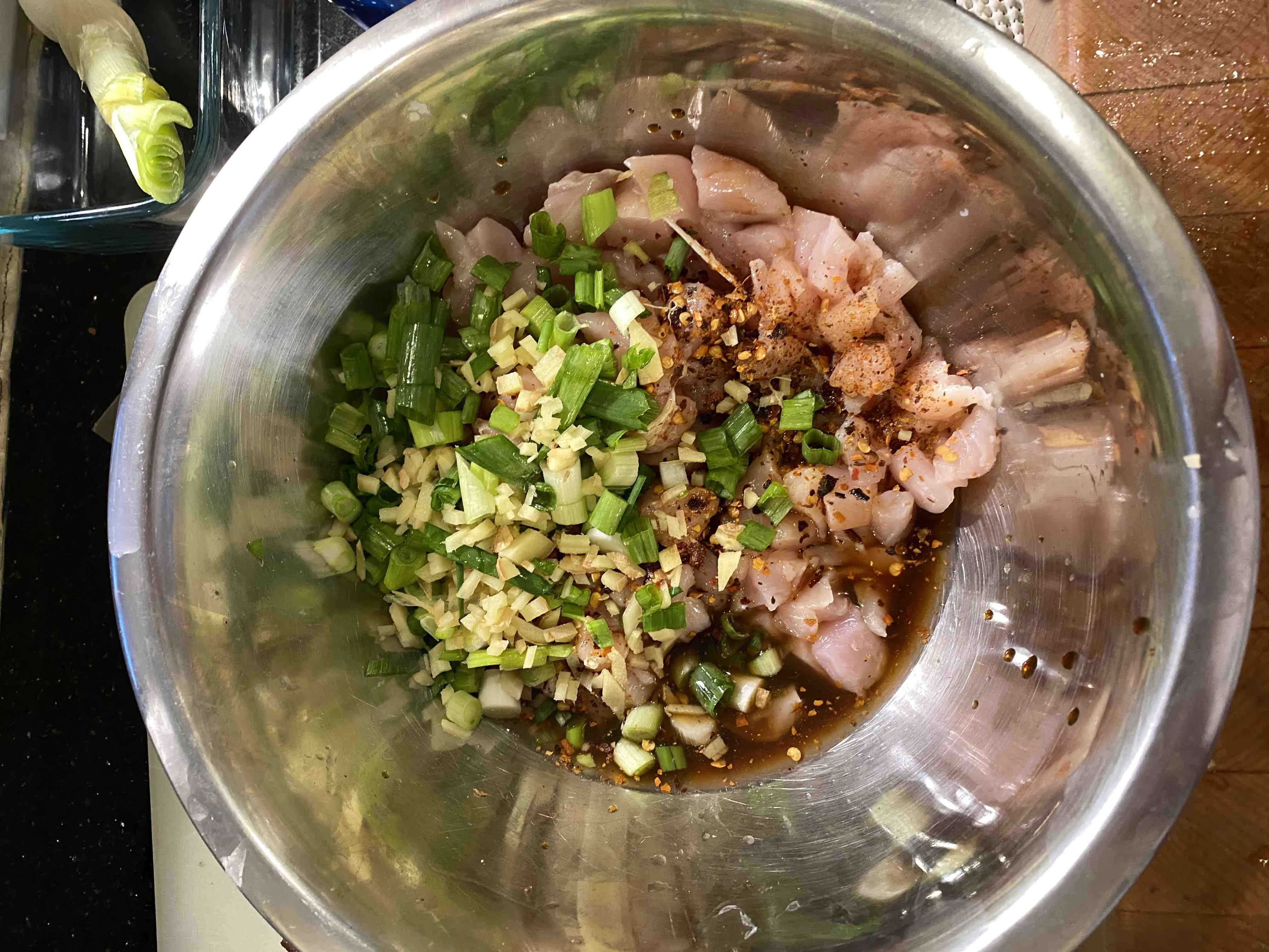 Chicken with aromatics and sauce before marinating.