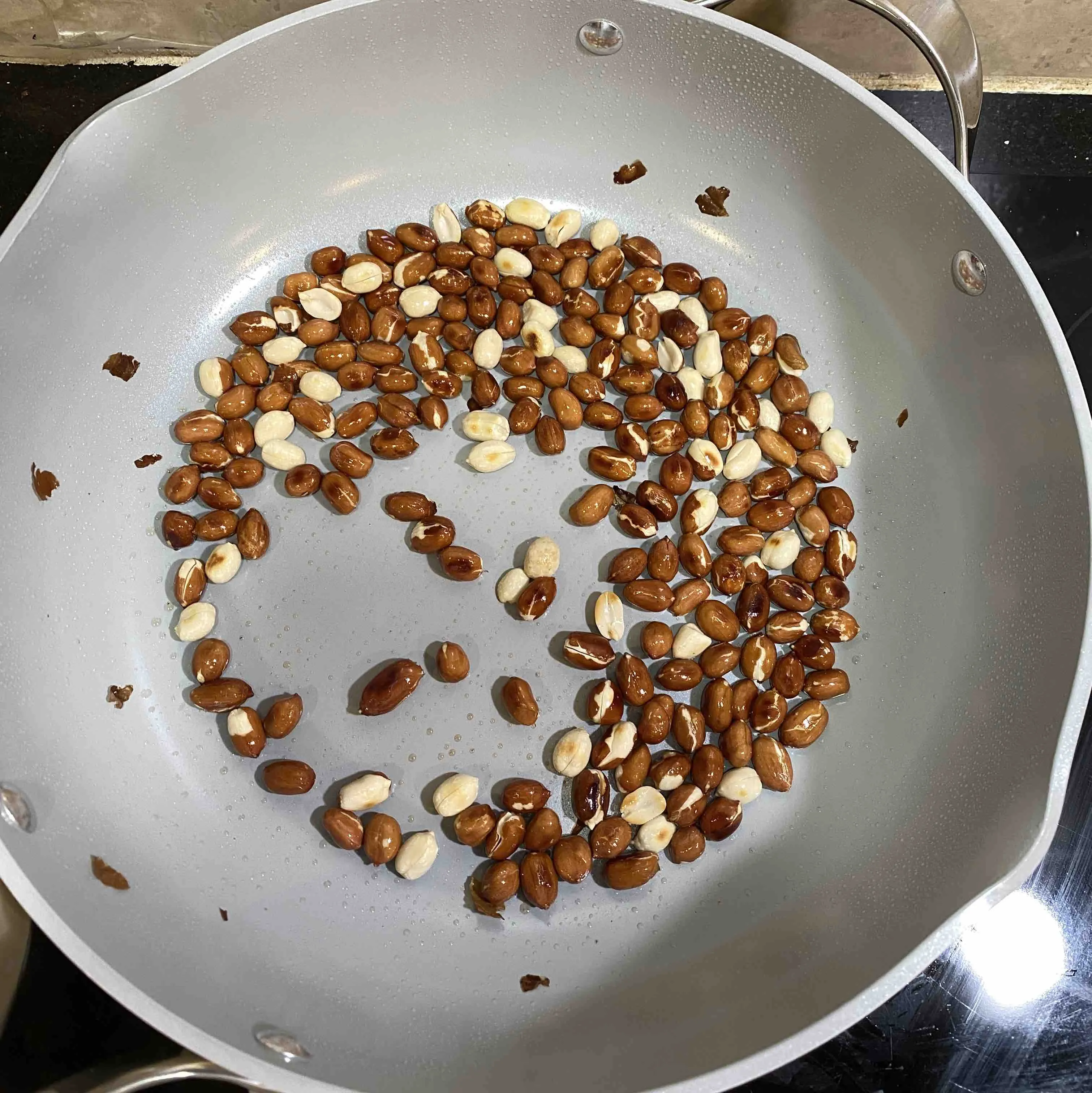 Peanuts browned with a little char before they come out of the pan.