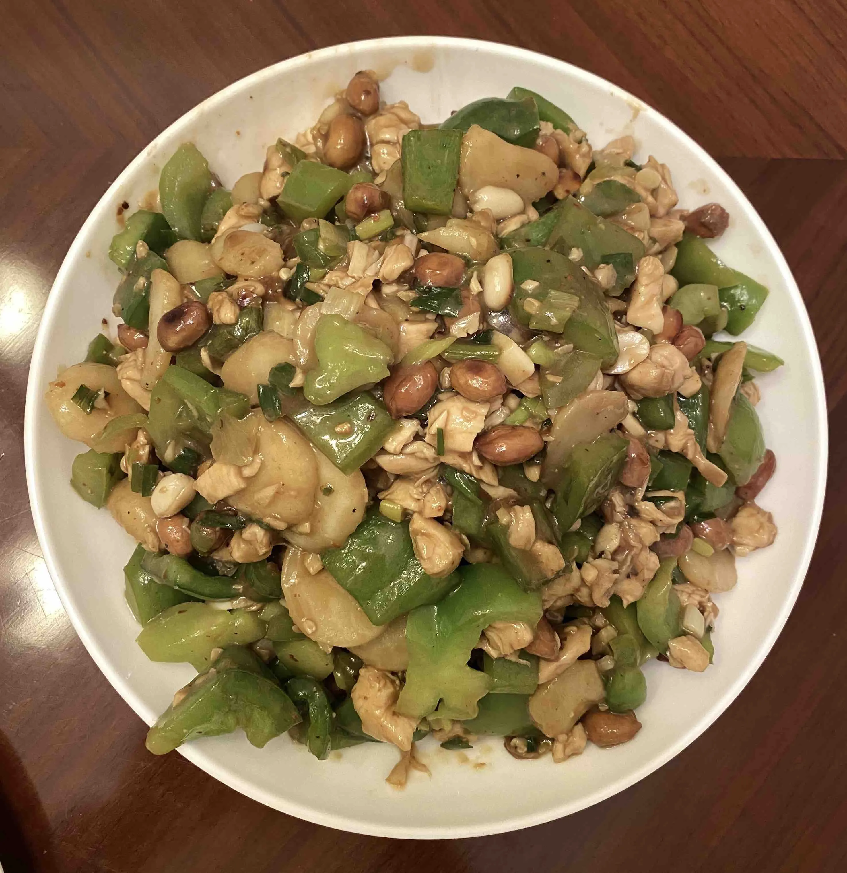 Finished plate of kung pao chicken with peanuts and green peppers